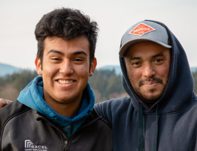 Two young men in sweaters smile for the camera