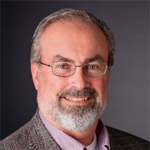 Head shot of a bearded man wearing glasses