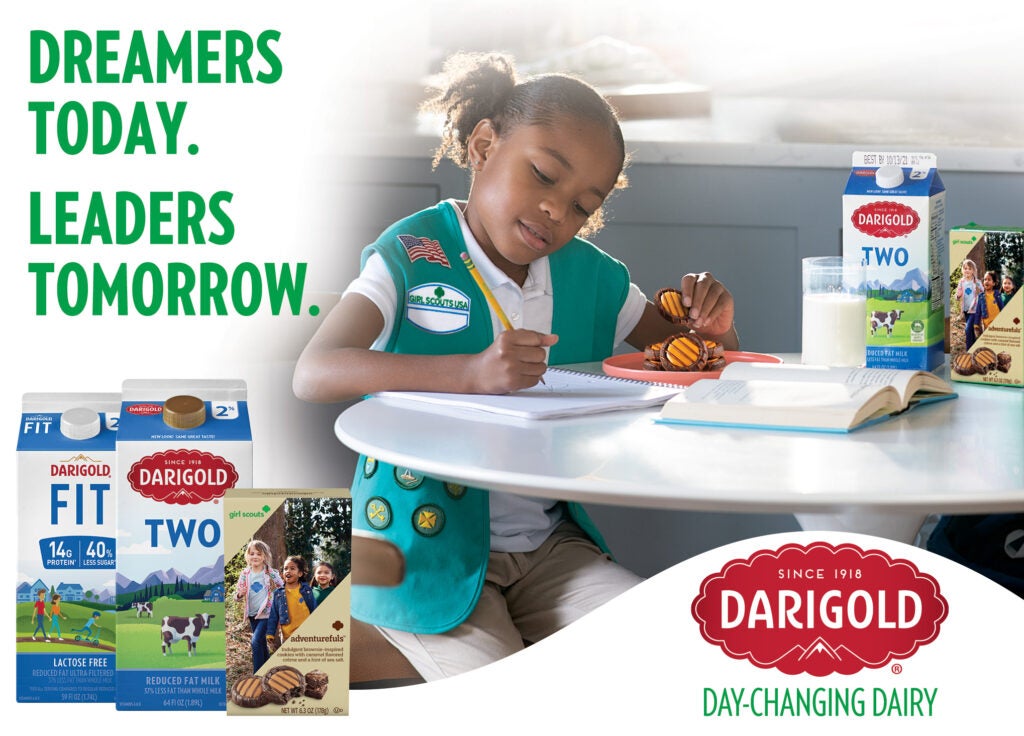 Girl studying at table with Darigold milk and Girl Scouts cookies.