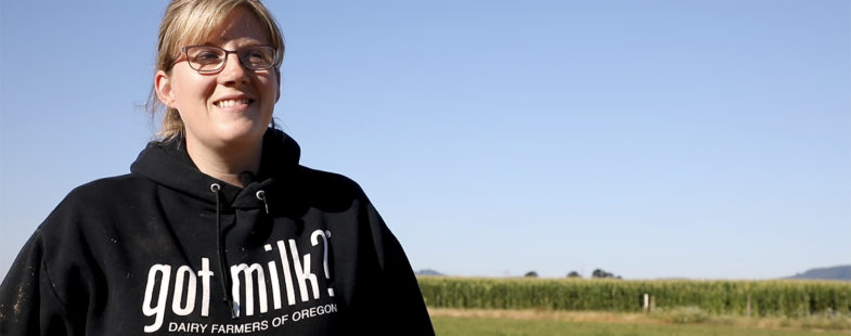 A female farmer poses for the camera in a field