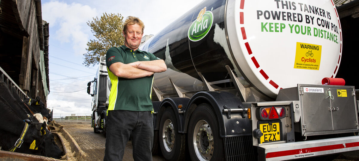 A man standing next to a milk truck poses for the camera