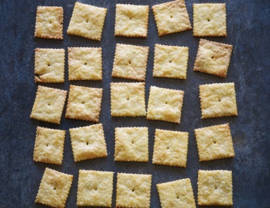 Small square crackers arranged on a dark surface