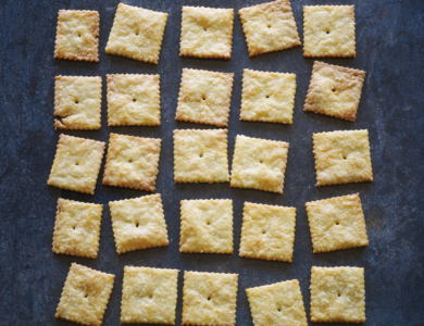 Small square crackers arranged on a dark surface