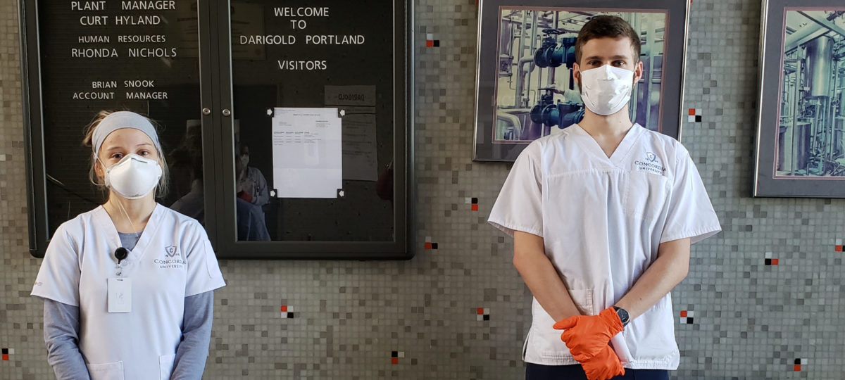 Two nursing students wearing PPE pose for the camera