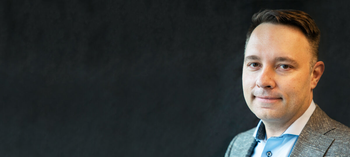 Professional man poses for the camera in front of a grey background