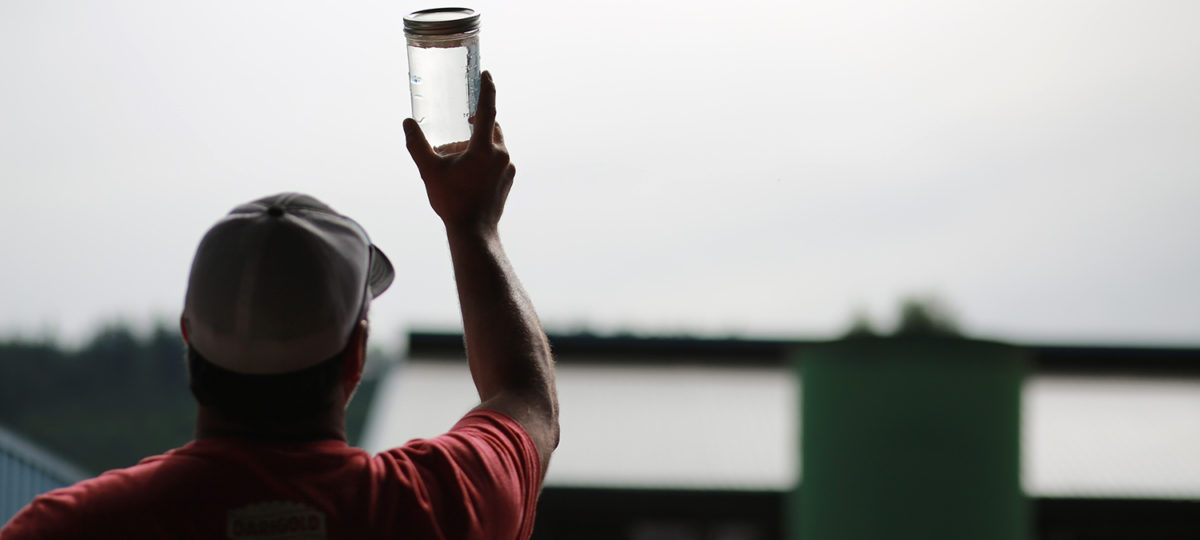 Man holding jar of clean water up to the sky