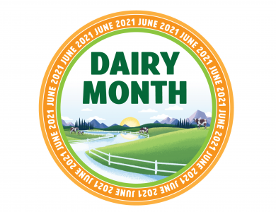 A round badge for June Dairy Month featuring cows at pasture, a meandering river and a fence