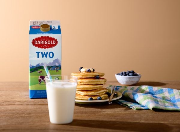 Creative shot of Darigold's two percent milk featured with milk, pancakes and blueberries
