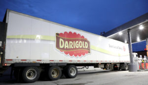 A large white truck refueling at a gas station