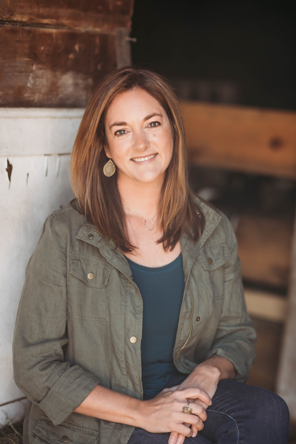 A woman poses for the camera in a rustic environment