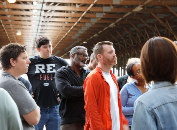 Several people in a barn looking stage left