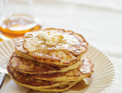 Syrup covered pancakes on a white plate