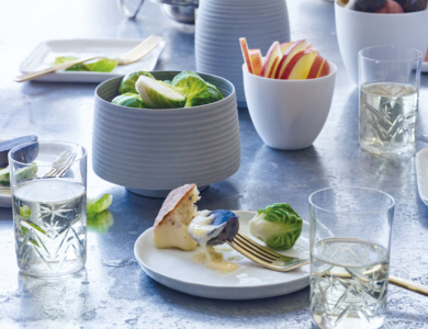 Beautiful lilac hued image of fruits and vegetables with a fondue bowl