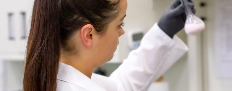 A woman in a lab coat testing samples