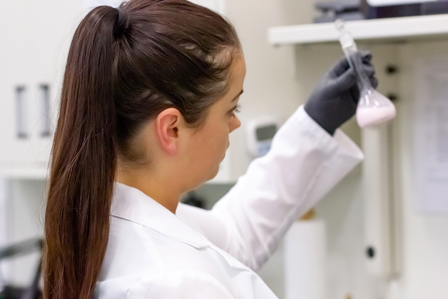 A woman in a lab coat testing samples