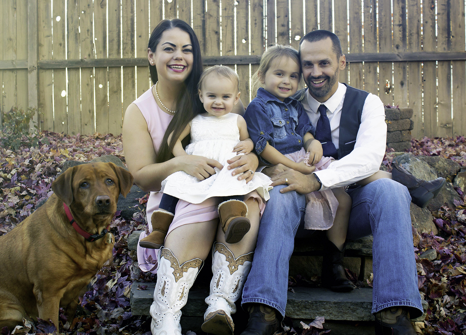 A mother, father, two daughters and a dog pose for the camera