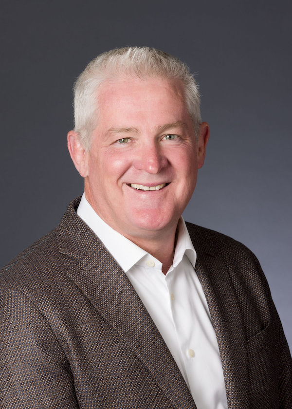 Professional portrait of a man with white hair, white shirt and a blazer