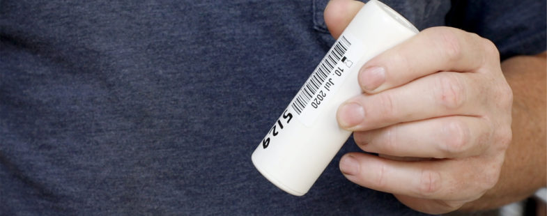 Man with blue shirt holds a small white sensor