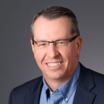 A man wearing glasses poses for the camera