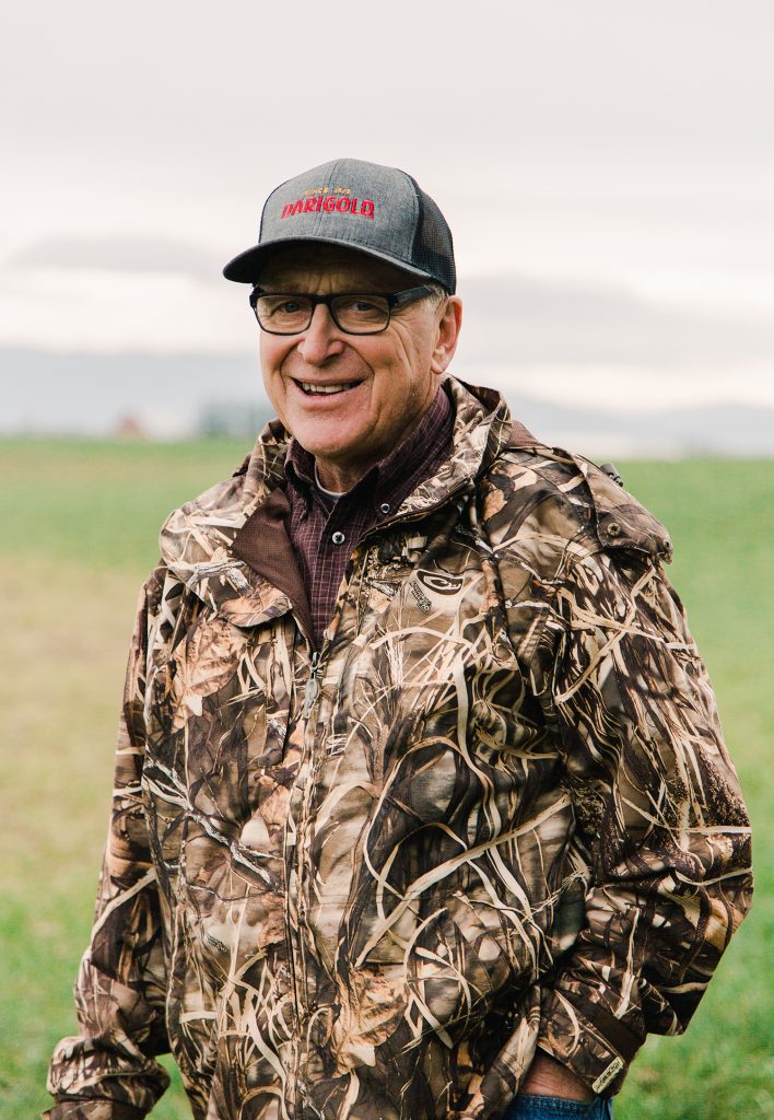 A man wearing a cap and camouflage jacket poses for the camera