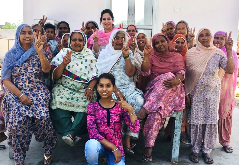 A group of women in saris pose for the camera