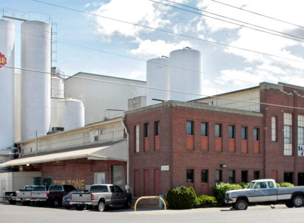 A dairy processing plant with silos and a brick building