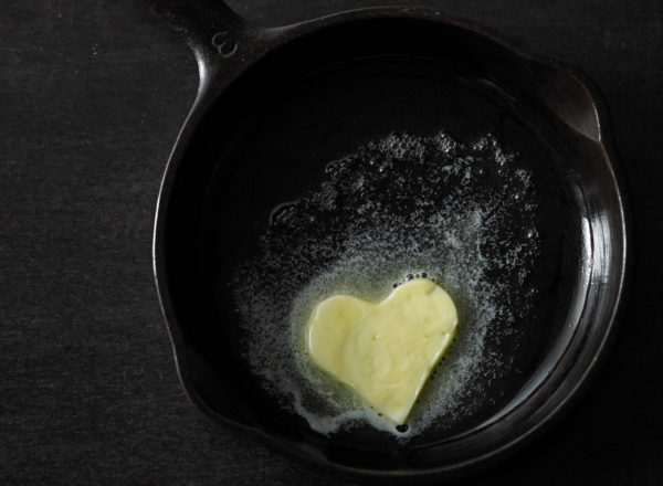 A cast iron pot with a heart-shaped piece of melting butter