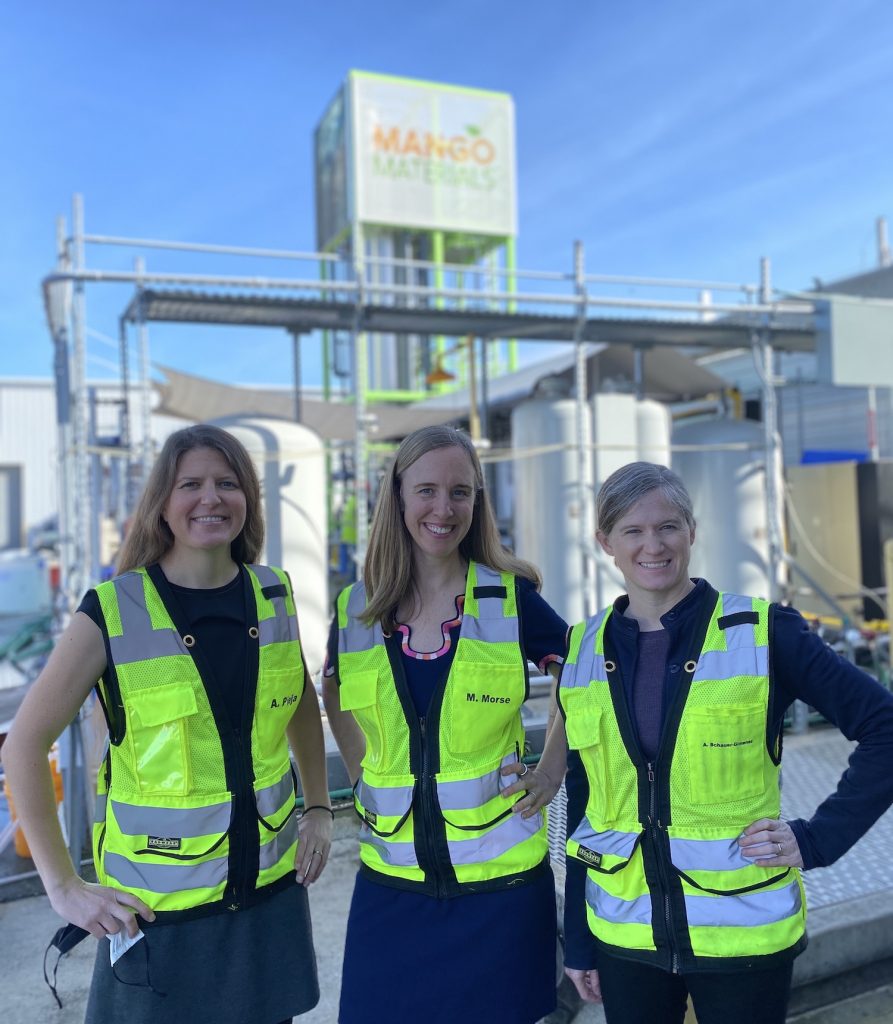 Three women in yellow jackets pose for the camera