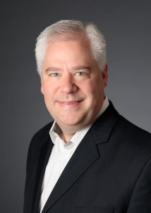 Man in a suit poses for camera