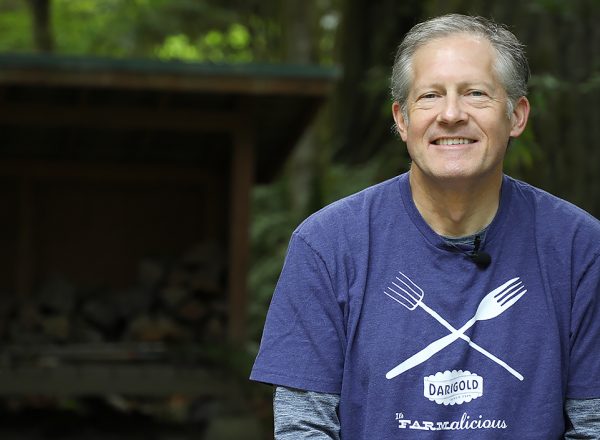 White man with purple shirt poses for the camera