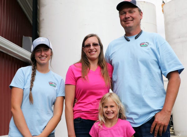 Portrait of a family in front of farm storage tanks