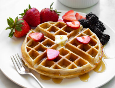 Belgian waffle with fruit on a white plate